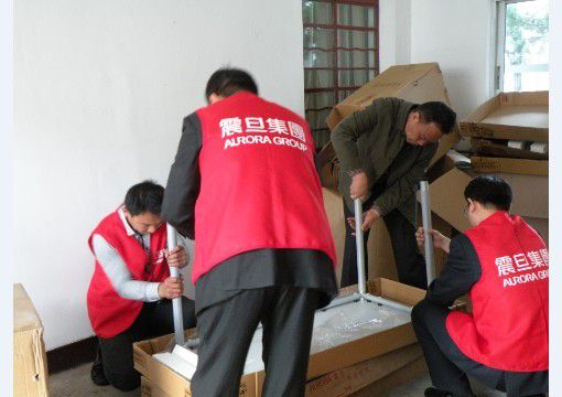行銷組李家暉總監(jiān)(右一)、家具上海事業(yè)部閘北責(zé)任中心楊侃經(jīng)理(左二)、崇明縣新河鎮(zhèn)民政辦秦衛(wèi)明主任(右二)一起動手參與組裝辦公桌，大家熱情高漲