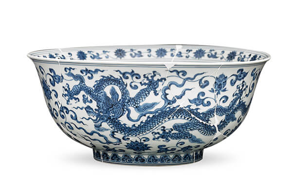明宣德．龍紋碗+二個龍紋順著環(huán)形器面伸展肢體，以前視和回首的姿態(tài)在花叢里穿梭追逐。（圖二）