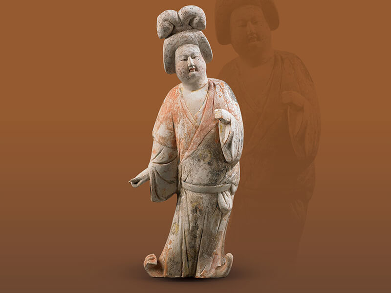 唐代．加彩仕女俑+女子頭挽雙髻，身穿低胸內(nèi)搭衣與寬袖長(zhǎng)衫，表面涂繪各種顏料，突顯衣著和發(fā)式。（圖一）