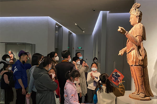 圖一：親子家庭共同探索六樓展廳，在展品前聽志愿者講解。